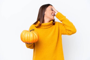 Beyaz arka planda izole edilmiş bir balkabağı tutan genç beyaz kadın bir şey fark etti ve çözüme niyetlendi.