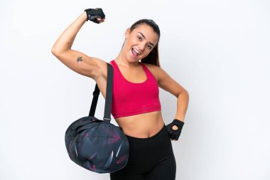 Spor çantalı genç bir kadın beyaz arka planda izole edilmiş güçlü bir jest yapıyor.