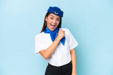Airplane stewardess caucasian woman isolated on blue background celebrating a victory