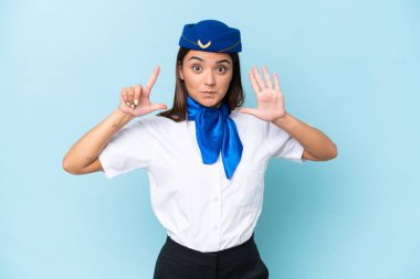 Airplane stewardess caucasian woman isolated on blue background counting seven with fingers