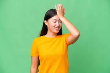 İzole edilmiş arka planda genç Asyalı kadın parmaklarıyla işaret veriyor.