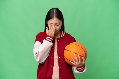Young basketball player asian woman over isolated background with tired and sick expression