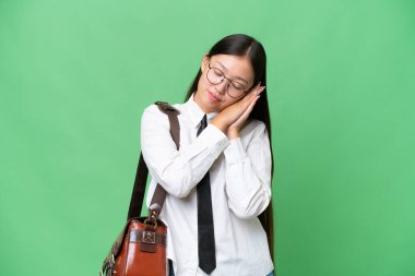 Young Asian business woman over isolated background making sleep gesture in dorable expression