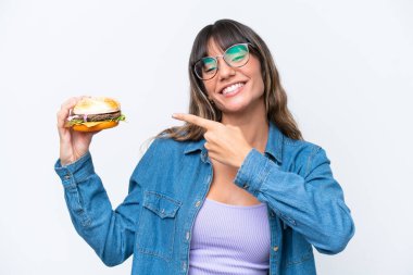 Beyaz arka planda izole edilmiş bir hamburger tutan beyaz bir kadın.