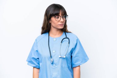 Young caucasian nurse woman isolated on white background looking to the side