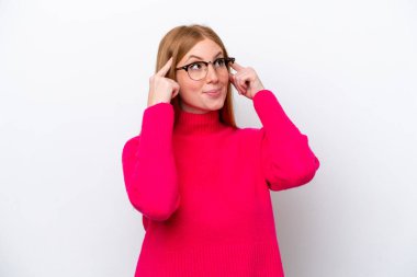 Genç kızıl saçlı kadın beyaz arka planda izole edilmiş. Şüpheleri ve düşünceleri var.