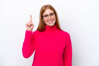 Beyaz arka planda izole edilmiş genç kızıl kadın harika bir fikre işaret ediyor.