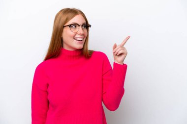 Genç kızıl saçlı kadın, beyaz arka planda izole edilmiş bir şekilde parmağını kaldırarak çözümü bulmaya çalışıyor.