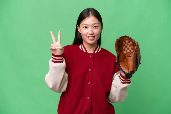 若いですアジアの女性とともに野球手袋上の隔離された背景笑顔とショー勝利サイン — ストック写真