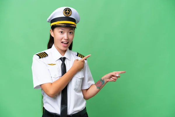 Airplane Pilot Asian Woman Isolated Background Surprised Pointing Side — Stockfoto