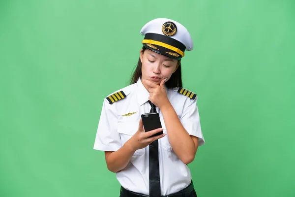 Airplane Pilot Asian Woman Isolated Background Thinking Sending Message — 스톡 사진