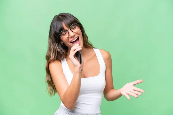 Young Caucasian Woman Isolated Background Using Mobile Phone Singing — Foto Stock