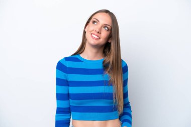 Beyaz arka planda izole edilmiş genç beyaz kadın yukarı bakarken bir fikir düşünüyor.