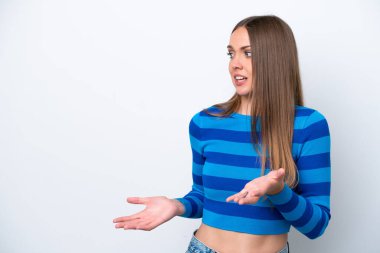 Beyaz arka planda beyaz tenli genç bir kadın. Sürpriz bir ifadeyle yan tarafa bakıyor.