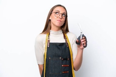 Genç terzi kadın beyaz arka planda izole edilmiş ve yukarı bakıyor.