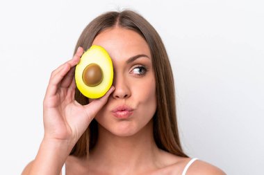 Beyaz arka planda avakado tutan beyaz bir kadın. Portreyi kapat