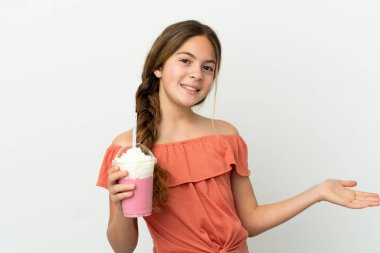 Beyaz arka planda izole edilmiş çilekli milkshake 'li küçük beyaz kız davet etmek için ellerini yana uzatıyor.