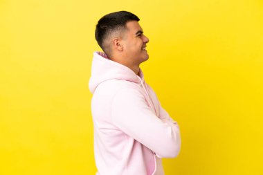 Sarı arka planda, yalıtılmış genç ve yakışıklı bir adam var.