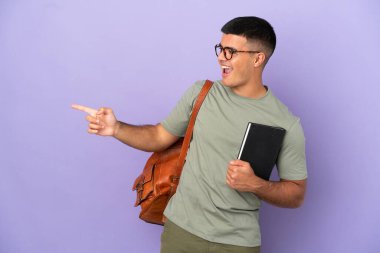 Handsome student man over isolated background pointing finger to the side and presenting a product