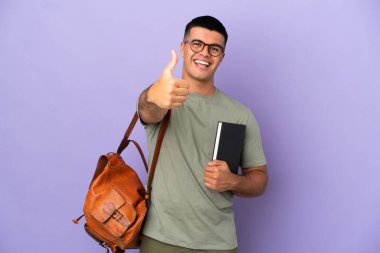 Handsome student man over isolated background with thumbs up because something good has happened