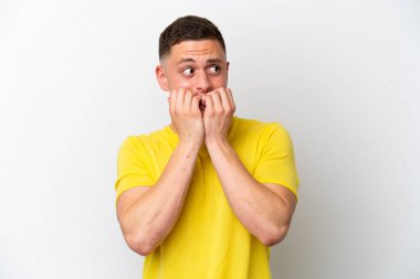 Beyaz arka planda izole edilmiş genç Brezilyalı gergin ve korkmuş bir adam elleriyle suni teneffüs yapıyor.