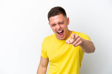 Beyaz arka planda izole edilmiş genç Brezilyalı adam hayal kırıklığına uğramış ve ön tarafı işaret ediyor.