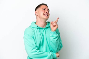 Beyaz arka planda izole edilmiş genç Brezilyalı adam harika bir fikre işaret ediyor.