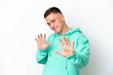 Beyaz arka planda izole edilmiş genç Brezilyalı adam sinirleri öne doğru geriliyor.