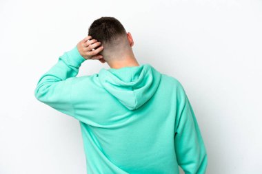 Genç Brezilyalı adam beyaz arka planda izole edilmiş ve düşünüyor.