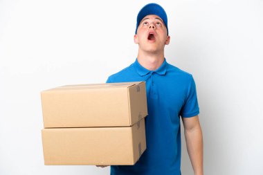Young delivery Brazilian man isolated ops white background looking up and with surprised expression