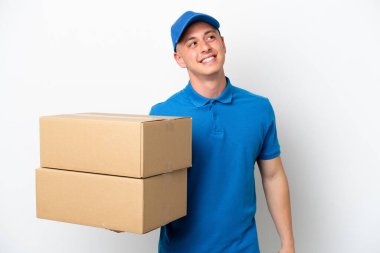 Young delivery Brazilian man isolated ops white background thinking an idea while looking up