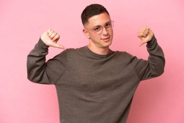 Genç Brezilyalı bir adam pembe arka planda soyutlanmış gururlu ve kendinden memnun