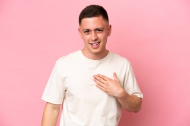 Pembe arka planda izole edilmiş genç Brezilyalı adam kendini işaret ediyor.