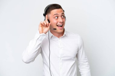 Tele pazarlamacı Brezilyalı bir adam beyaz arka planda izole edilmiş bir kulaklıkla çalışıyor. Çözümü bulmak için parmağını kaldırıyor.