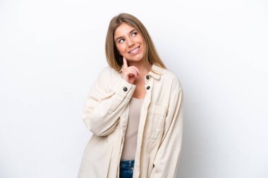 Kafkasyalı genç bir kadın beyaz fırında izole edilmiş bir şekilde yukarı bakarken bir fikir düşünüyor.