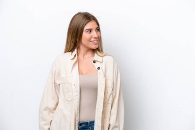 Beyaz fırında izole edilmiş genç beyaz kadın yan bakıyor ve gülümsüyor.