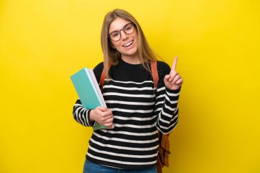 Young student woman isolated on yellow background background showing and lifting a finger in sign of the best