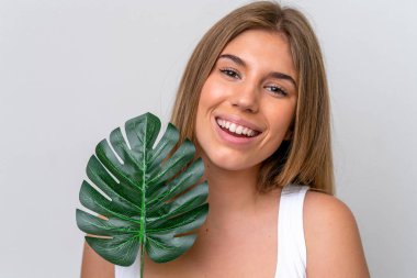Beyaz arka planda izole edilmiş beyaz bir kadın elinde mutlu bir ifadeyle bir palmiye yaprağı tutuyor. Portreyi kapat