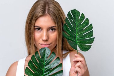 Beyaz arka planda, elinde palmiye yaprağı olan beyaz bir kadın. Portreyi kapat