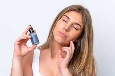 Beyaz arka planda izole edilmiş beyaz bir kadın elinde bir serum tutuyor. Portreyi kapat