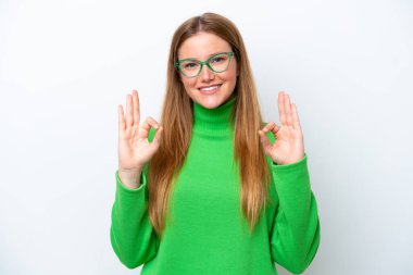 Beyaz arka planda izole edilmiş beyaz bir kadın iki eliyle tamam işareti gösteriyor.