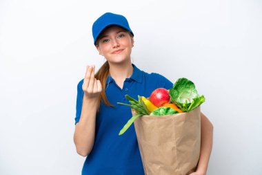 Genç teslimatçı kadın beyaz arka planda izole edilmiş bir paket yiyecek alıyor ve para hareketi yapıyor.
