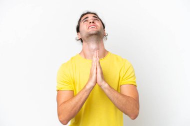 Caucasian handsome man isolated on white background keeps palm together. Person asks for something