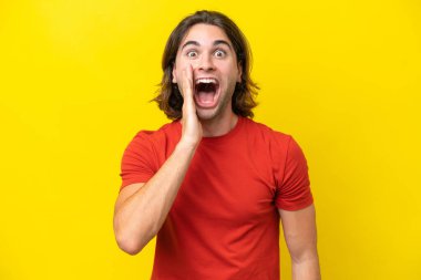 Caucasian handsome man isolated on yellow background with surprise and shocked facial expression