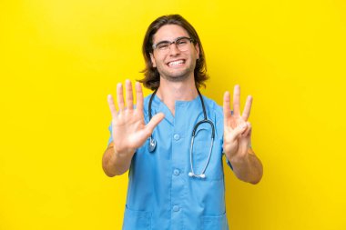 Young surgeon caucasian man isolated on yellow background counting eight with fingers