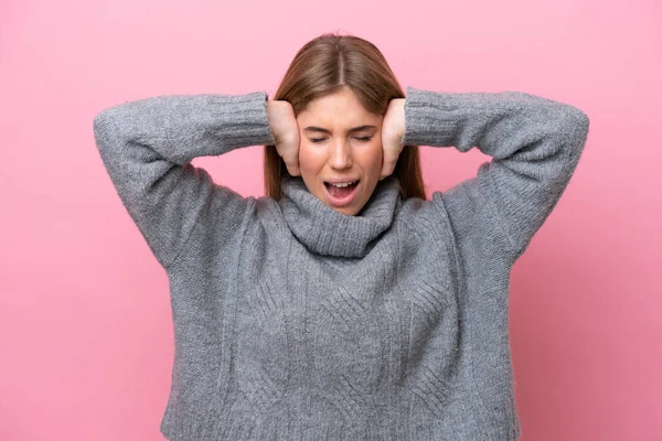 Pembe fırında izole edilmiş genç beyaz kadın hayal kırıklığına uğramış ve kulaklarını kapatmış.