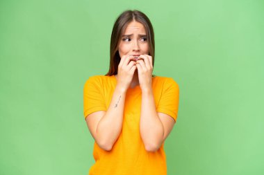 Young pretty caucasian woman over isolated background nervous and scared putting hands to mouth