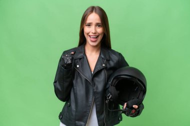 Young pretty caucasian woman with a motorcycle helmet over isolated background celebrating a victory in winner position