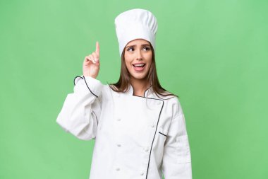 Young chef caucasian woman over isolated background intending to realizes the solution while lifting a finger up