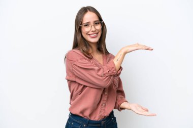 Young pretty caucasian woman isolated on white background holding copyspace to insert an ad